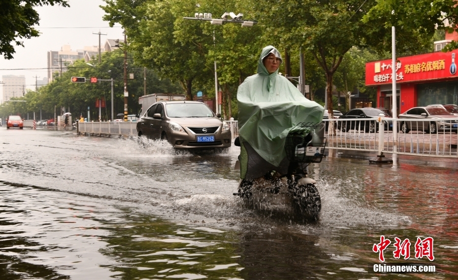 市民在石家庄市栾城区街头冒雨出行 市民在石家庄市栾城区街头冒雨出行